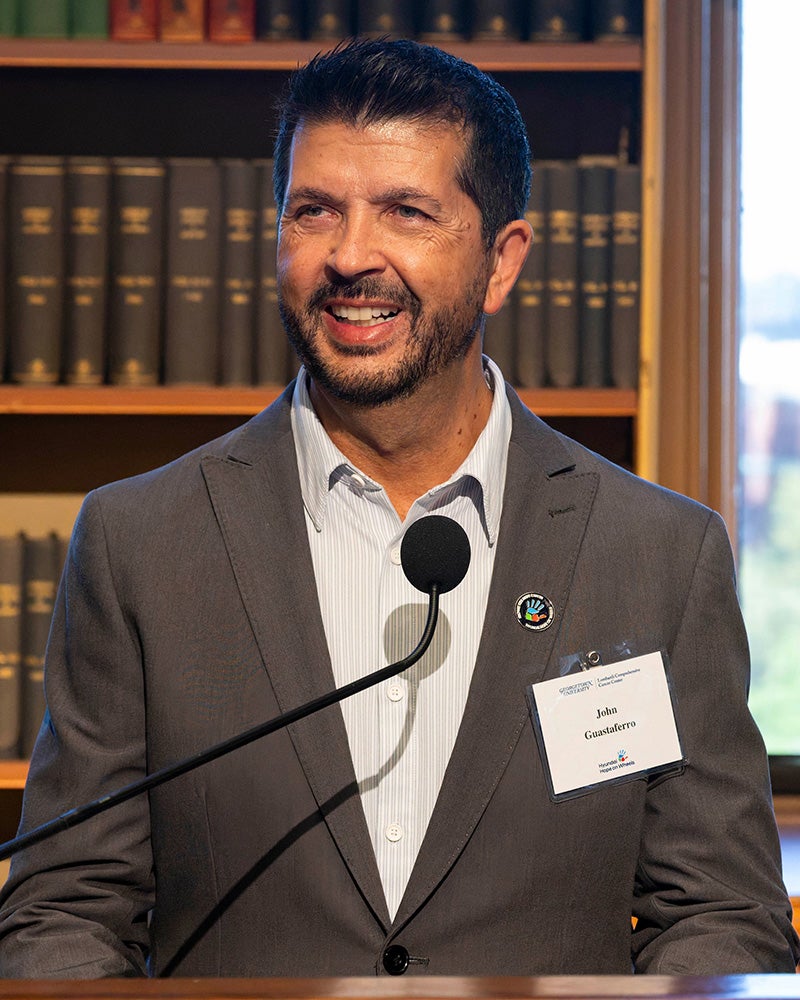 John Guastaferro speaks from a podium in Riggs Library