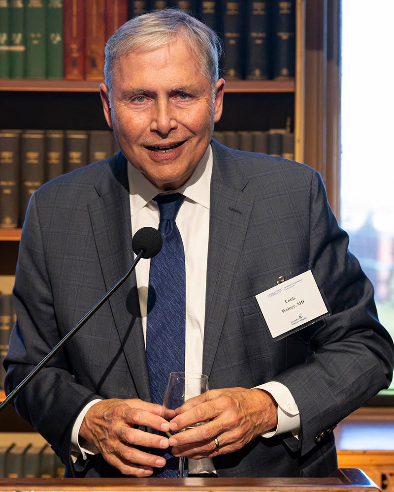 Louis Weiner speaks from a podium in Riggs Library
