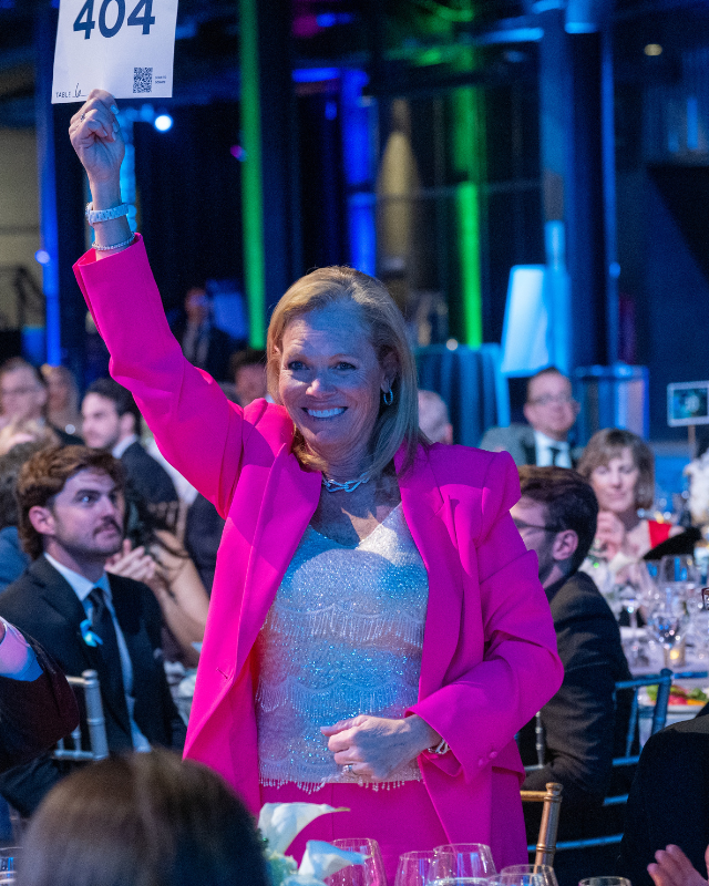 Supporter Cindy Stark smiles standing from the audience at the Lombardi Gala.