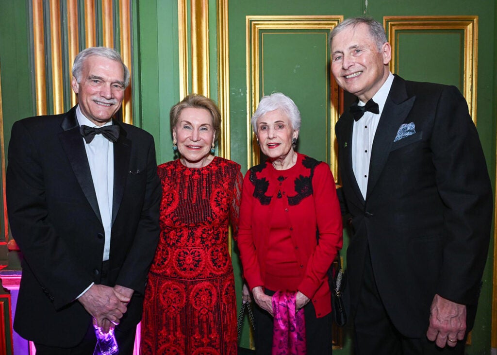 Four individuals stand together