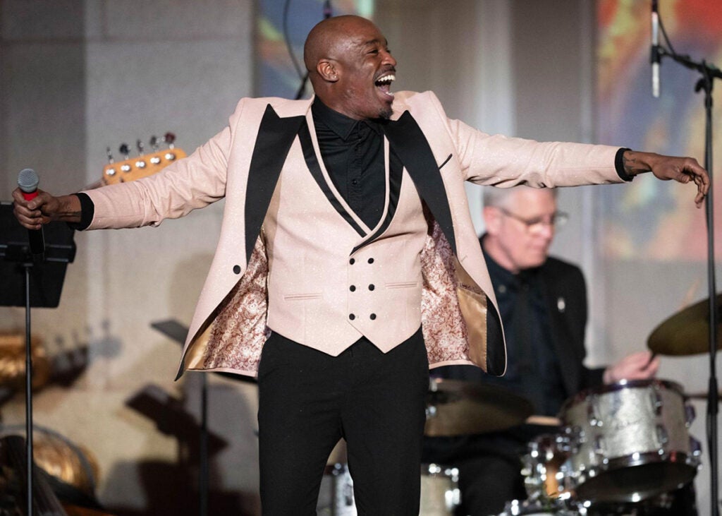 Rayshun LaMarr sings onstage with a band