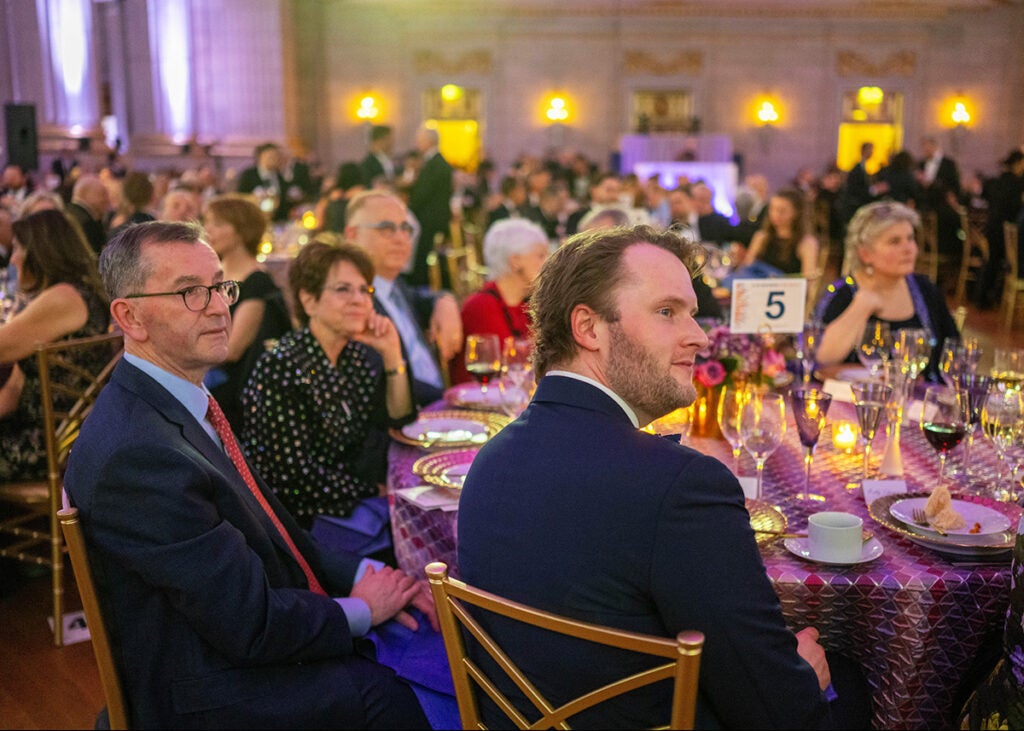 A view of people seated at tables in the Mellon Auditorium