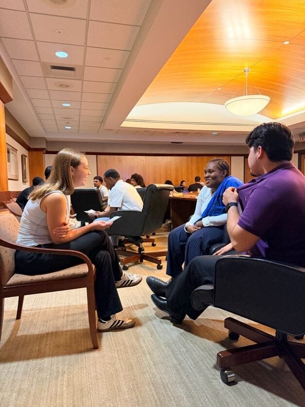 Students seating down talking to each other at a networking event