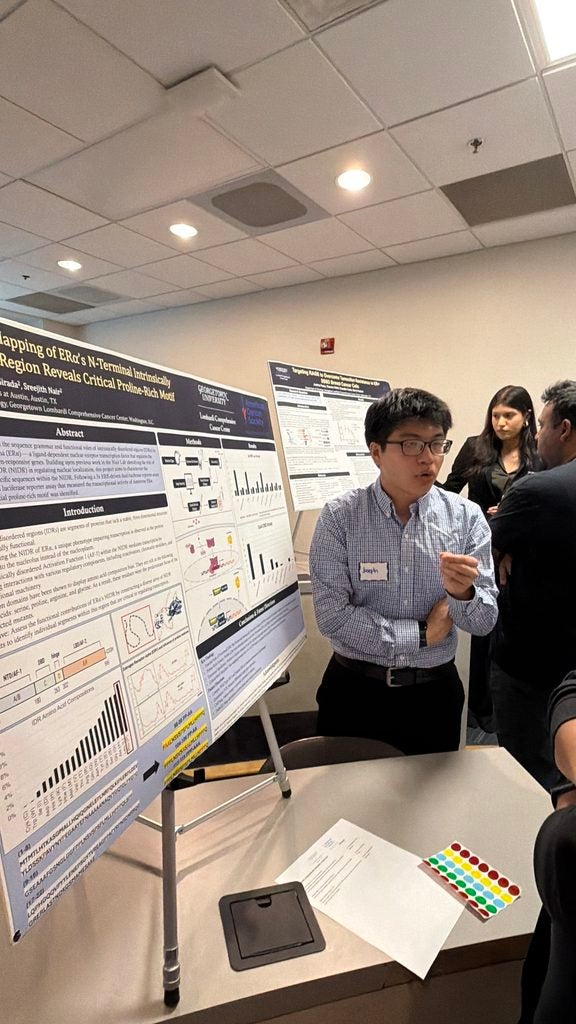 Young man by his poster presenting to someone listening