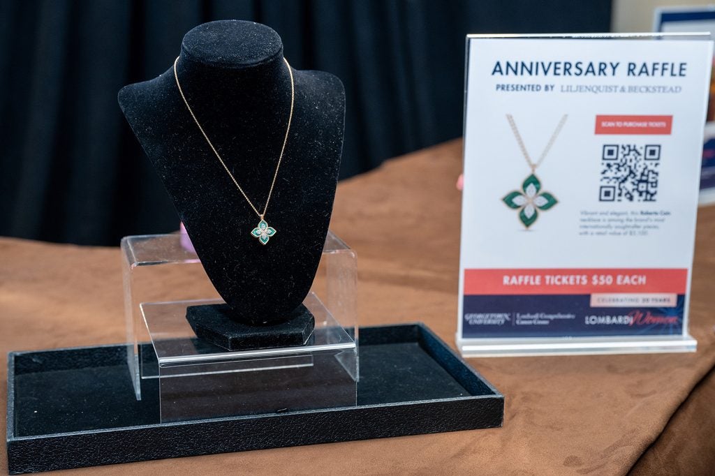 A pendant hangs on a display with a sign describing the item next to it